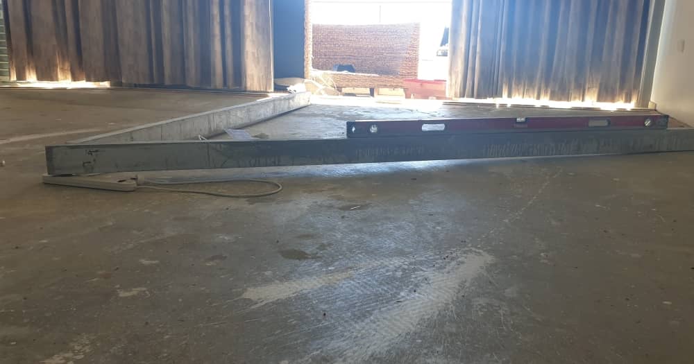 A straight edge set up with a spirt level to determine subfloor gaps.